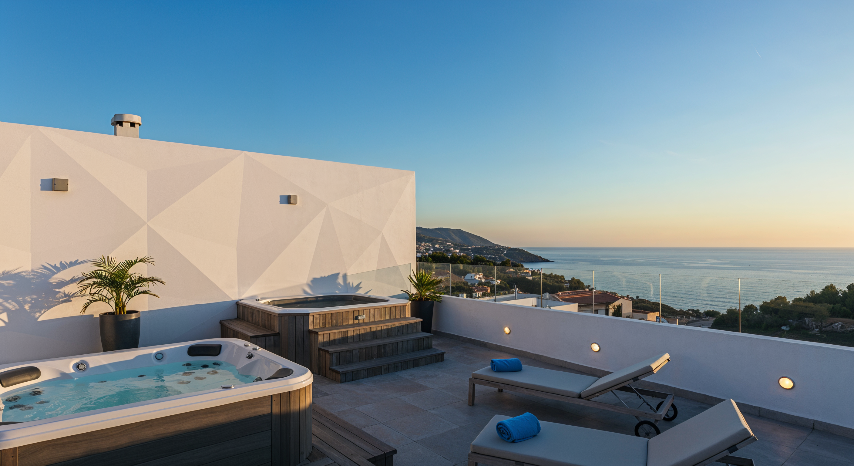 Rooftop con spa, cielo abierto y la costa al fondo.